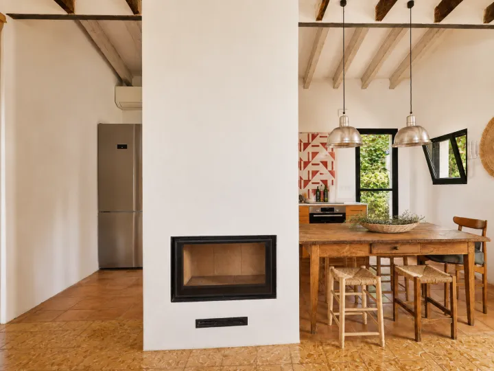 Comedor con chimenea y cocina abierta en villa de Dénia