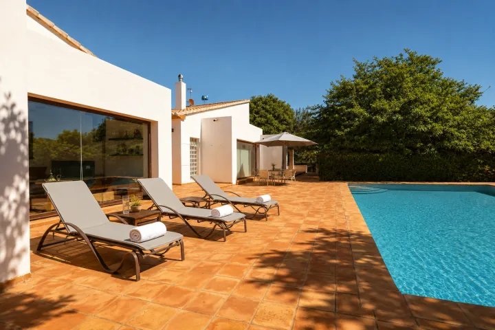 Terraza con tumbonas y piscina climatizada en finca de Ondara