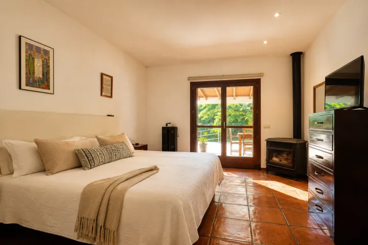 Dormitorio con chimenea en villa de la finca de Ondara